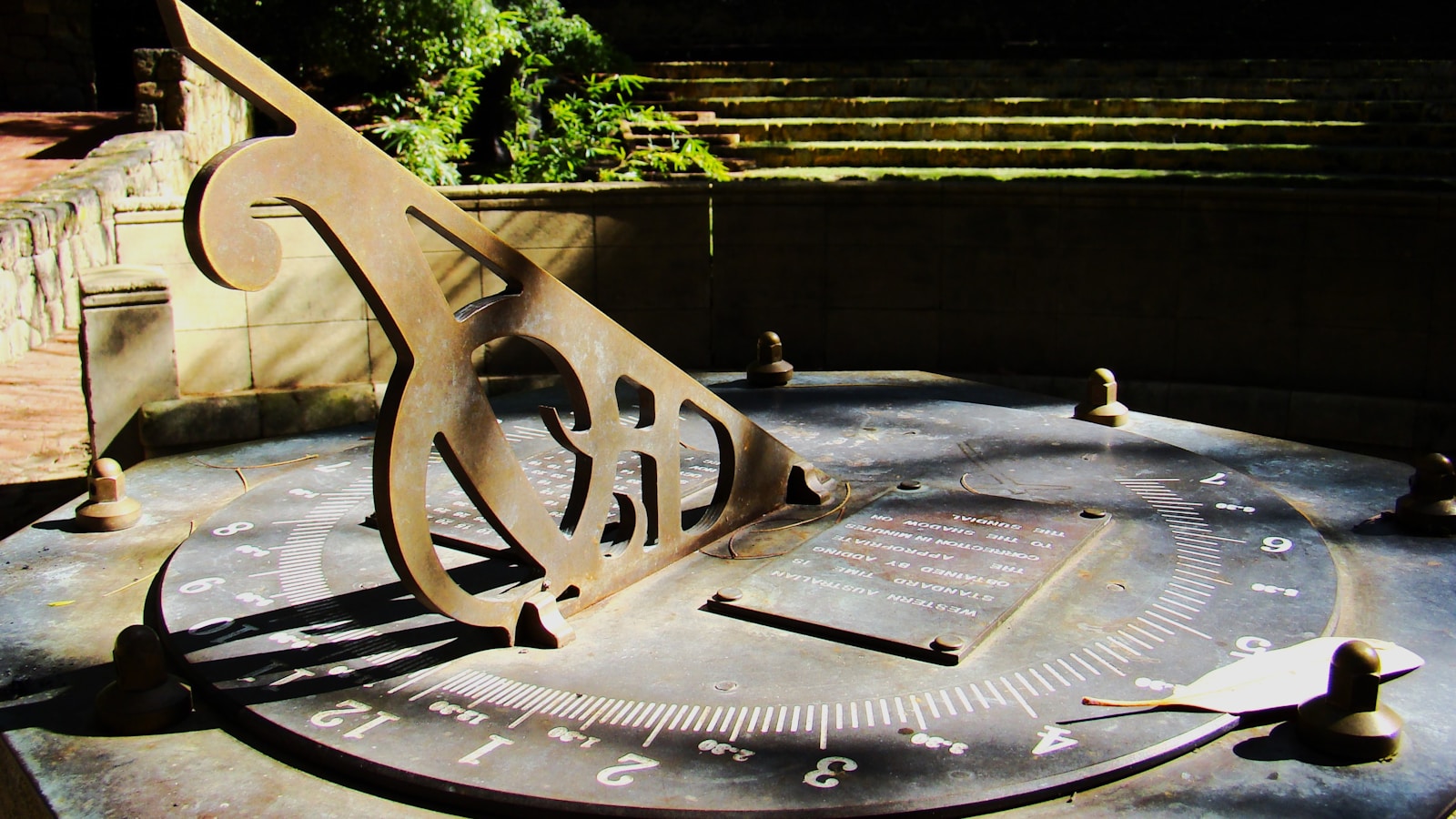 A weathered sundial in a garden setting.