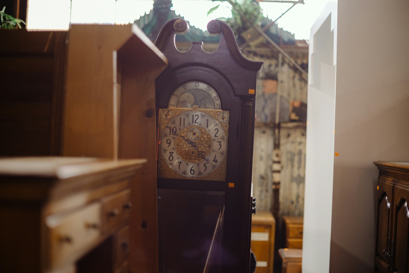 Antique grandfather clock in a cluttered room